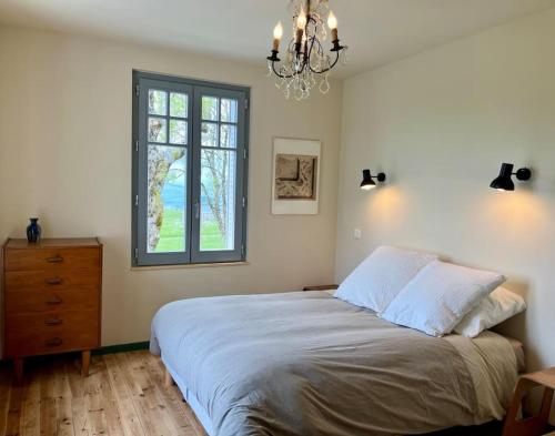 une chambre avec un grand lit et une fenêtre dans l'établissement Maison 50 Belvédère du Cézallier, à Marcenat