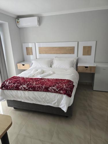 a bedroom with a large bed with a red blanket at Sekret Zone Hotel in New Germany