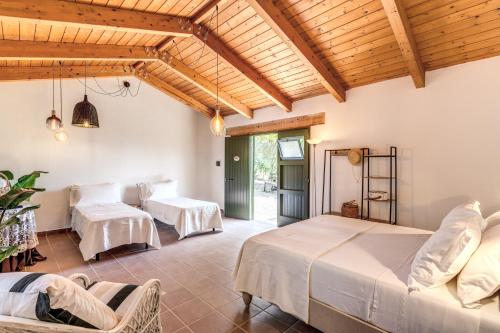 two beds in a room with wooden ceilings at Casale Giancesare Villa Agricola in Capaccio-Paestum