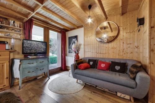 a living room with a couch and a television at Chalet Barme de l'Ours 1 in Val dʼIsère