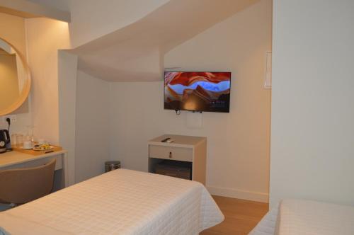 a bedroom with two beds and a tv on the wall at LEONDIANA Boutique Hotel in Larnaca