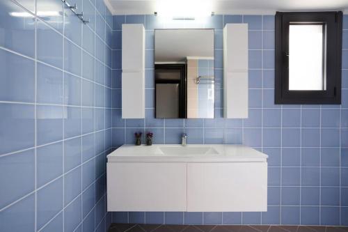 a bathroom with a white sink and a mirror at Mythique Pool Residence in Foinikiá