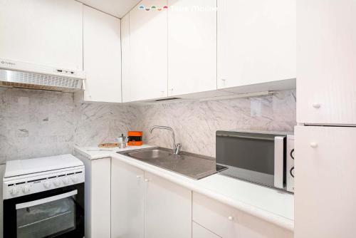 a white kitchen with a sink and a microwave at Maryce, Terre Marine in Lerici