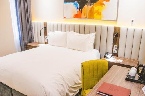 a hotel room with a bed and a desk with a desk at AMBER CITY HOTELS in Owerri
