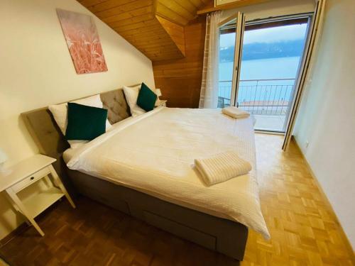 a bedroom with a large bed with a large window at Lake View Residence in Niederried