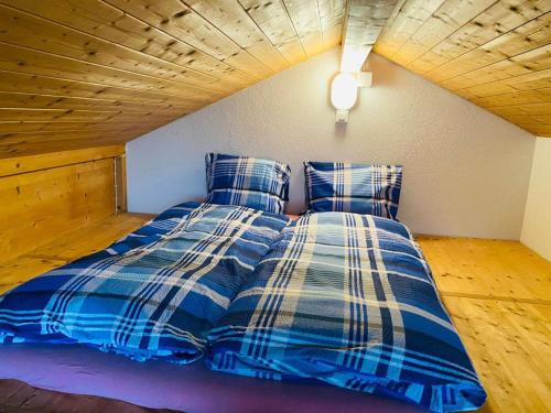 a bed with blue and white sheets in a room at Lake View Residence in Niederried
