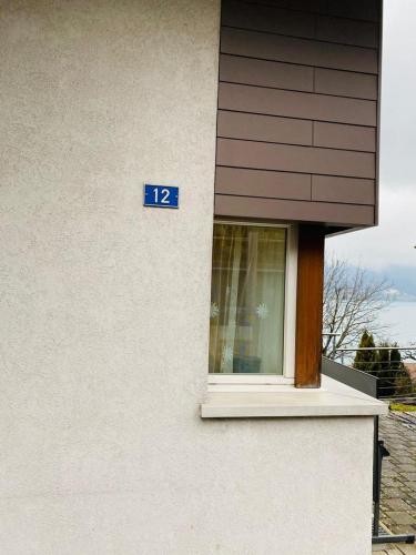 a building with a window with a blue sign on it at Lake View Residence in Niederried
