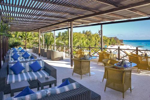 a resort patio with couches and tables and the ocean at Z Hotel & Z2 Hotel in Nungwi