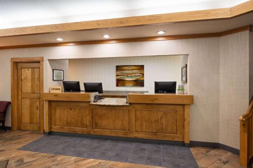 a lobby with a reception desk with two computers on it at Days Inn & Suites by Wyndham Bozeman in Bozeman