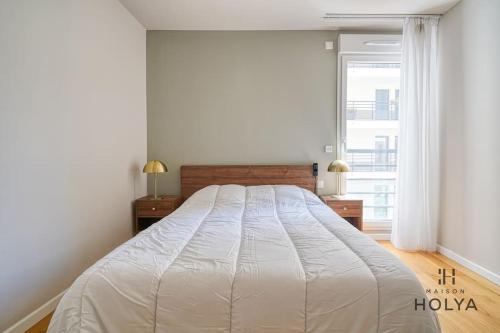 une chambre avec un grand lit blanc avec deux tables de nuit dans l'établissement Le Clairsemé - En bordure de Paris - 364B, à Issy-les-Moulineaux