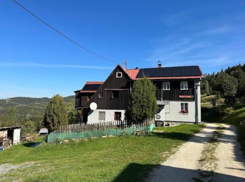 a black and white house on a hill with a dirt road at Rancho u Bolka in Miedzygorze