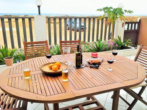 a wooden table with a bowl of fruit and a bottle of wine at Avalon Villa in Santa Maria