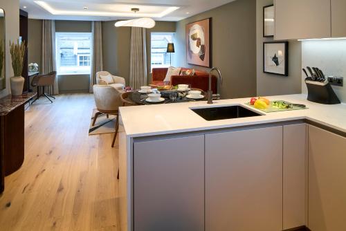 a kitchen and living room with a counter and a sink at Cheval Phoenix House at Sloane Square in London