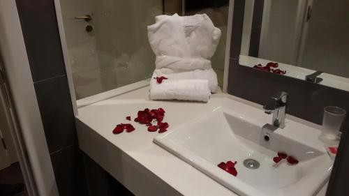 a bathroom sink with red flowers on it at Relax Hôtel Oujda in Oujda