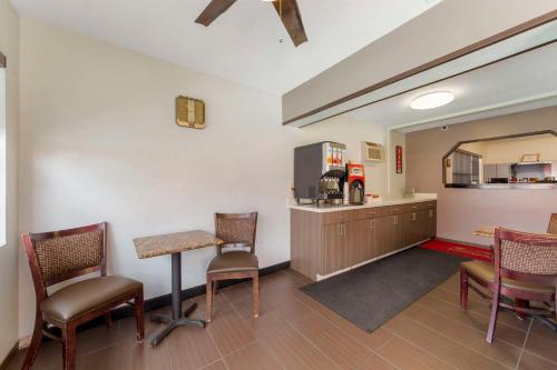 a waiting room with a table and chairs and a kitchen at Fort Lauderdale Gardens Inn & Suites Ft Lauderdale International Airport in Hollywood