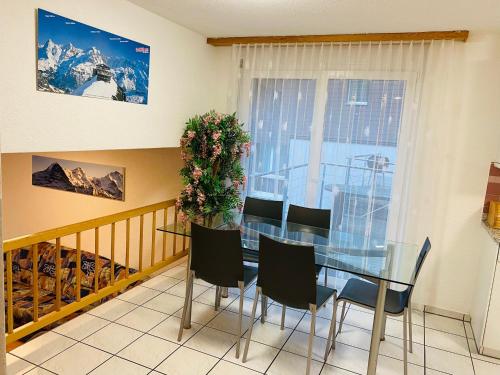 a dining room with a glass table and chairs at Lake View Residence in Niederried