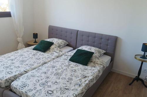 - un lit avec 2 oreillers verts dans l'établissement Villa spacieuse avec piscine, secteur très calme, à Nîmes