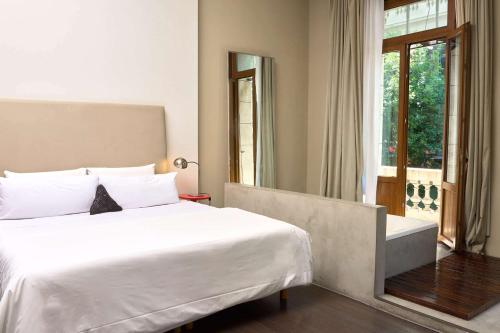 Un dormitorio con una gran cama blanca y una ventana. en Esplendor by Wyndham Buenos Aires, en Buenos Aires