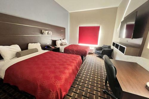 a hotel room with two beds and a red bedspread at Econo Lodge Augusta West near Fort Eisenhower in Augusta