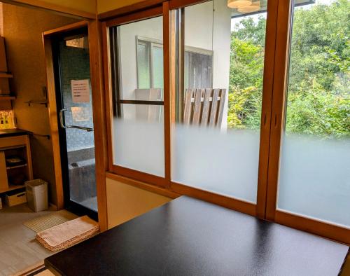 a room with doors and windows with a bench in front at Ryoso Yufuin Yamadaya in Yufuin
