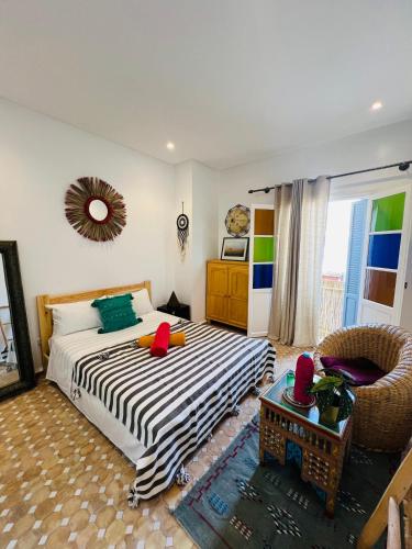 a bedroom with a bed and a chair at Art Riad Au Bord De La Mer in El Jadida