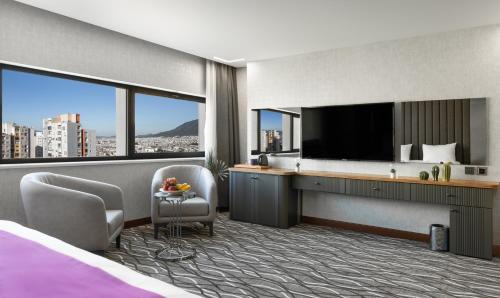 a hotel room with a bed and a television at Lilium Hotel & Suites in Bursa