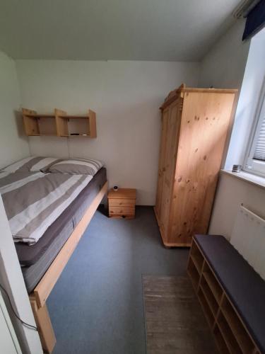 a bedroom with a bunk bed and a wooden cabinet at Apartment am Rodelberg in Braunlage