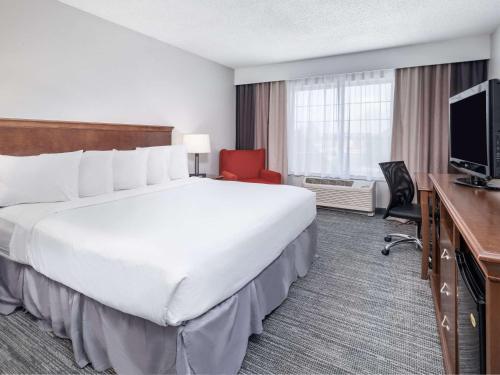 a hotel room with a large bed and a television at Country Inn & Suites by Radisson, Toledo, OH in Maumee