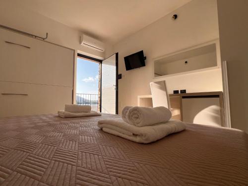 a bedroom with a large bed with towels on it at B&b Il Poggio Eccelso in Ogliastro Cilento