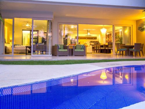 a swimming pool in front of a house at Marival Distinct All-Suites & World Spa - Handwritten Collection in Nuevo Vallarta 