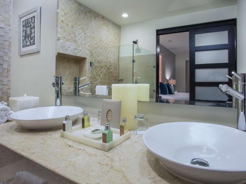 a bathroom with two sinks and a large mirror at Marival Distinct All-Suites & World Spa - Handwritten Collection in Nuevo Vallarta 