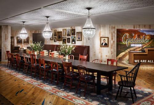 a dining room with a long table and chairs at Graduate by Hilton Storrs in Storrs