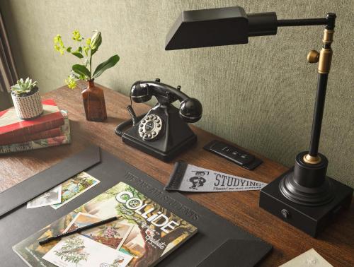 a desk with a telephone and a book on it at Graduate by Hilton Storrs in Storrs