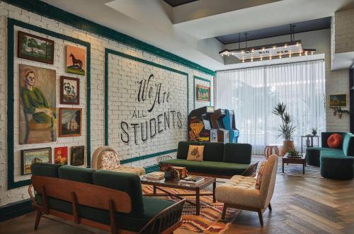 a living room with green furniture and a brick wall at Graduate by Hilton Lincoln in Lincoln