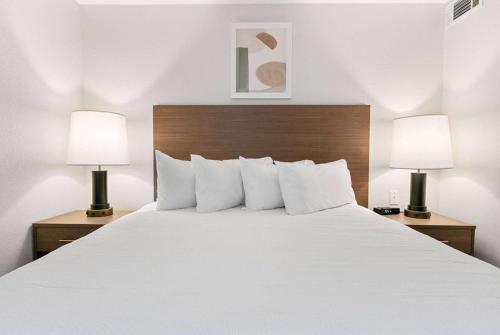 a bedroom with a large white bed with two lamps at WaterWalk Extended Stay by Wyndham Atlanta Perimeter in Atlanta