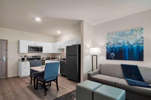 a living room with a couch and a table and a kitchen at WaterWalk Extended Stay by Wyndham Charlotte - Arrowood in Charlotte