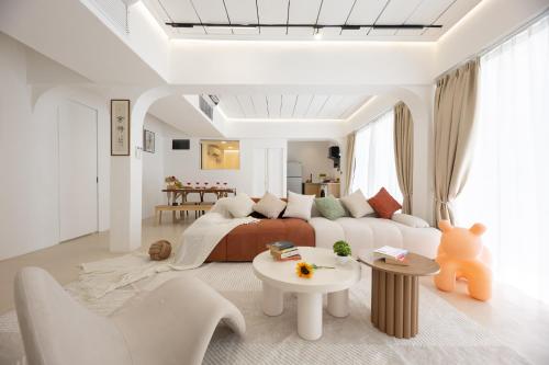 バンコクにあるRatchada Retreat Boutique Suitesのソファとテーブルのある白いリビングルーム