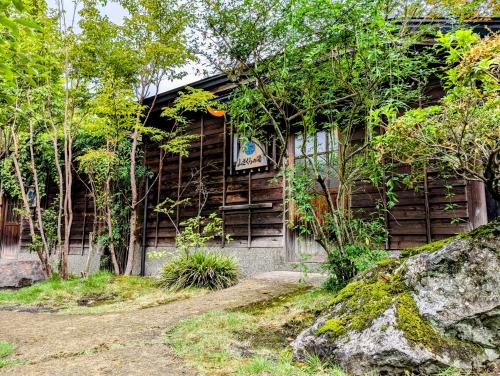 a wooden house with a sign on the side of it at Ryoso Yufuin Yamadaya in Yufuin