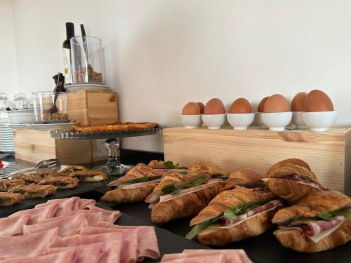 a table topped with sandwiches and croissants and eggs at Pensieri di Cavatina in Castelnuovo Berardenga