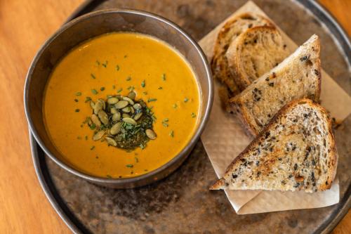 a bowl of soup and some slices of bread at The Farm - Azores Boutique House in Ponta Delgada