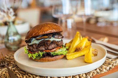a hamburger and french fries on a plate at The Farm - Azores Boutique House in Ponta Delgada