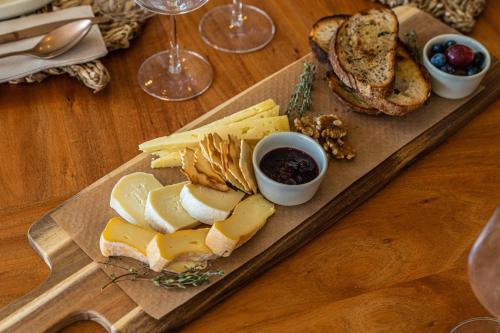 a plate of cheese and bread on a wooden table at The Farm - Azores Boutique House in Ponta Delgada