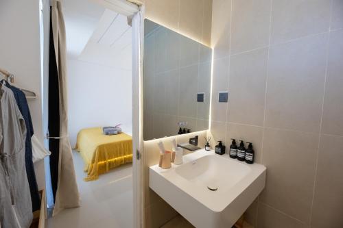 バンコクにあるRatchada Retreat Boutique Suitesの白い洗面台と鏡のあるバスルーム