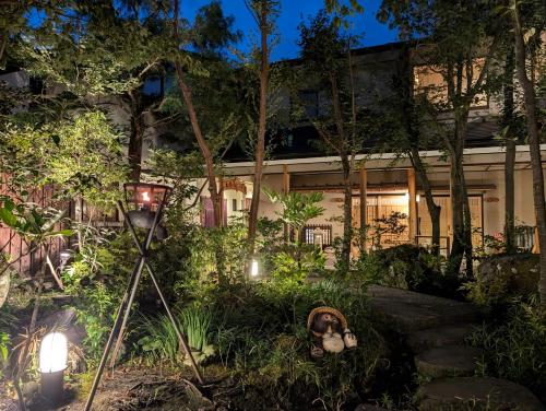 a house with a garden at night with lights at Ryoso Yufuin Yamadaya in Yufuin
