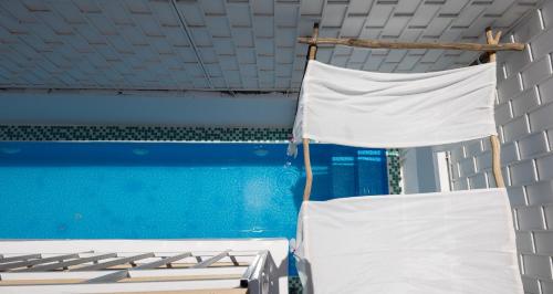 two white beds in a room with a pool at Ratchada Retreat Boutique Suites in Bangkok