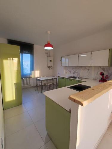 a kitchen with green and white cabinets and a table at La suite di Carola in Villasanta