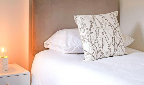a white pillow sitting on top of a bed at PLEASANT View Impressive Home In Stunning Rhondda Valley By Staystaycations in Pontypridd