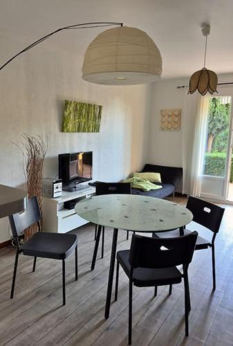 un salon avec une table et des chaises dans l'établissement Appart T2 -4 pers- rez-de-jardin proche plage -3 étoiles-, au Pradet