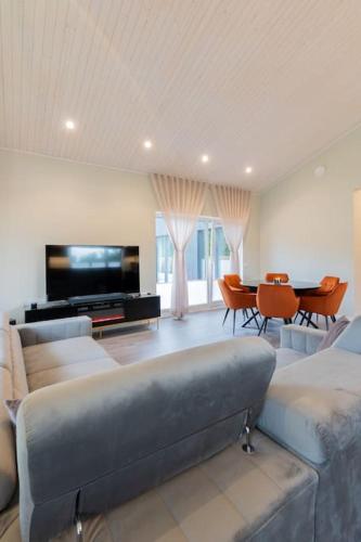 a large living room with a couch and a tv at Kolmnurga Villa in Audru