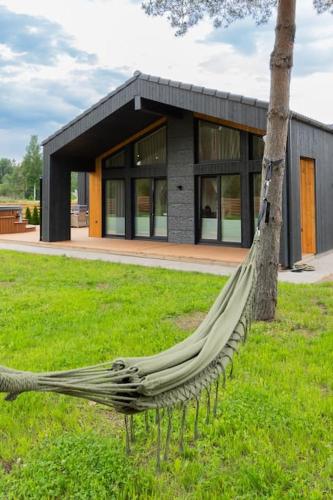a hammock in the grass in front of a building at Kolmnurga Villa in Audru